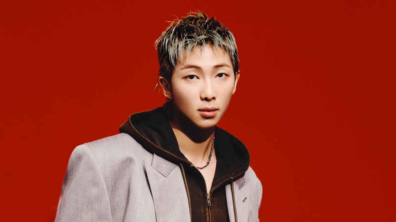 RM in rolling stone cover with a brown jacket and black hoodie.